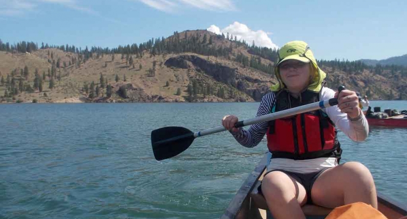 a student paddles a canoe on an outward bound expedition in the pacific northwest
